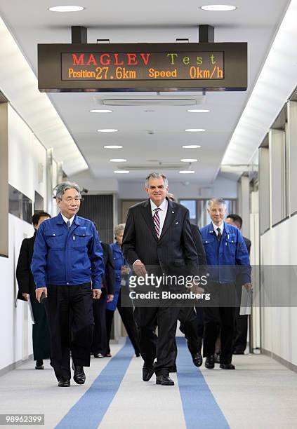 Ray LaHood, U.S. Transportation secretary, center, accompanied by Yoshiyuki Kasai, chairman of Central Japan Railway Co., left, walks on the platform...