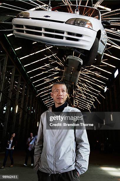 Artist Cai Guo-Qiang poses with his sculpture "Inopportune: Stage One" during a media preview of the 17th Biennale of Sydney at Cockatoo Island on...