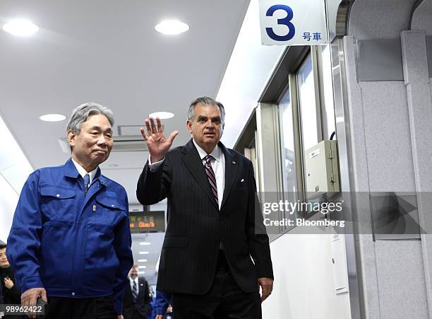 Ray LaHood, U.S. Transportation secretary, right, waves as he walks with Yoshiyuki Kasai, chairman of Central Japan Railway Co., on the platform to...