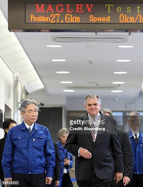 Ray LaHood, U.S. Transportation secretary, right, accompanied by Yoshiyuki Kasai, chairman of Central Japan Railway Co., left, walks on the platform...
