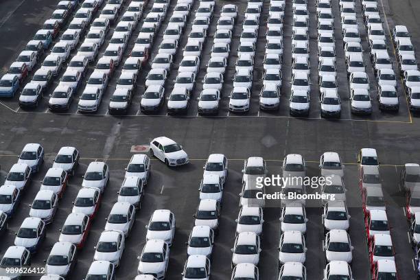 Newly manufactured Audi AG automobile is driven into a parking space as Volkswagen AG brand vehicles stand ahead of shipping outside the VW factory...