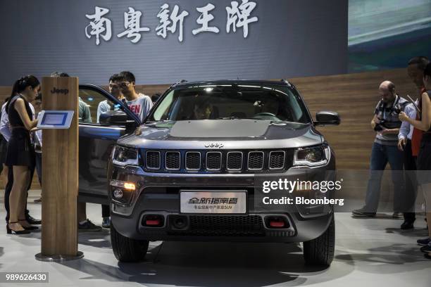 Attendees look at a Fiat Chrysler Automobiles NV Jeep Compass sports utility vehicle , manufactured by Guangzhou Automobile Group Co., on display at...