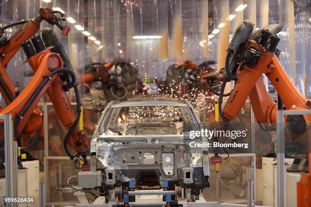 Robotic arms manufactured by Kuka AG operate on a Volkswagen Passat saloon chassis on the automated welding production line inside the VW factory in...