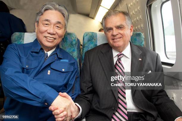 Transport Secretary Ray LaHood shakes hands with the chairman of the Central Japan Railway Yoshiaki Kasai during his test run on the Maglev train on...