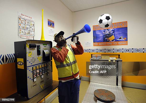 An Employee of the Kruger Mpumalanga International airport blows into a vuvuzela on May 7, 2010 in Nelspruit. Nelspruit is one of the 10 cities in...