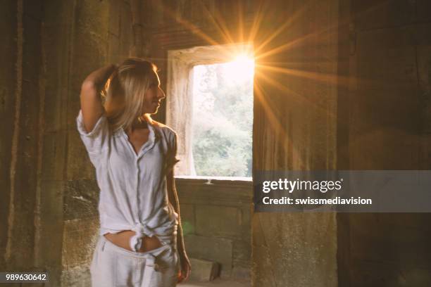 vy över turist resenären att utforska antika tempel på solnedgången, sunbeam passerar genom fönster. människor reser prospektering koncept - sun rays through window bildbanksfoton och bilder