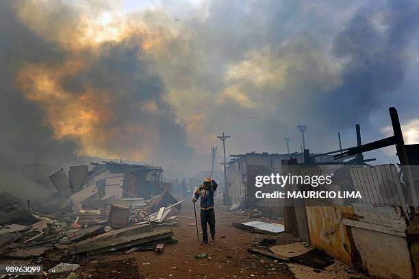 Resident tries to save his belongings from the fire during an eviction at Capao Redondo shantytown, southern outskirts of Sao Paulo, Brazil, on...