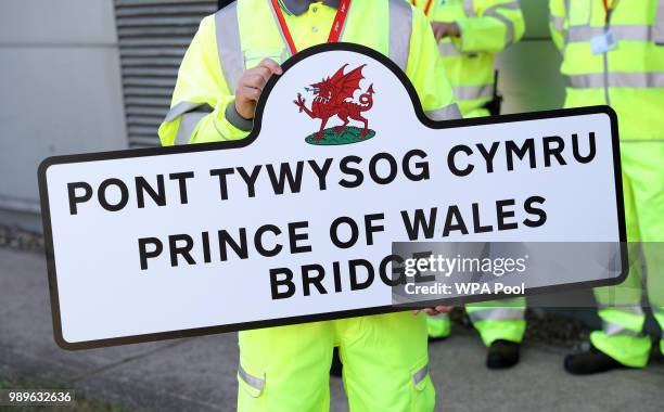 Maintenance worker holds up a sign for the new Prince of Wales Bridge, during the Prince of Wales and Duchess of Cornwall visit to the toll plaza...