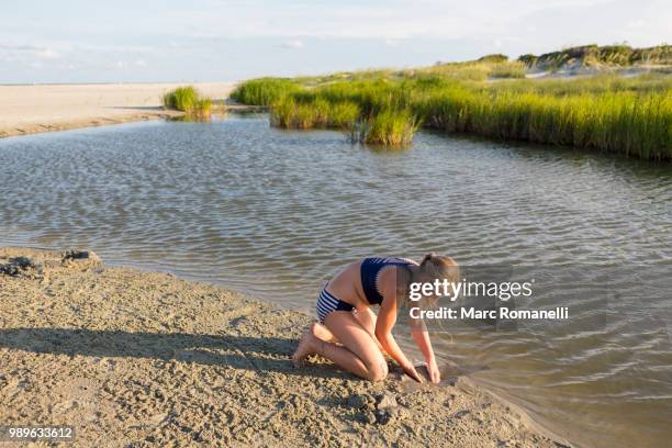 girl exploring waters edge - saint simons island stockfoto's en -beelden