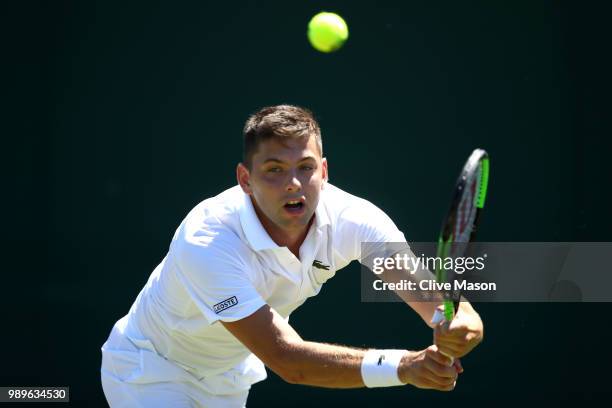 Filip Krajinovic of Serbia returns to Nicolas Jarry of Chile during their Men's Singles first round match on day one of the Wimbledon Lawn Tennis...