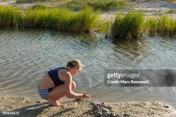 girl exploring waters edge - saint simons island stock-fotos und bilder