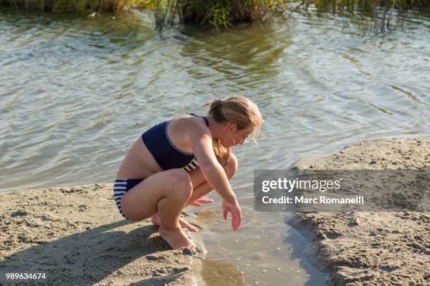 girl exploring waters edge - marc romanelli stock pictures, royalty-free photos & images