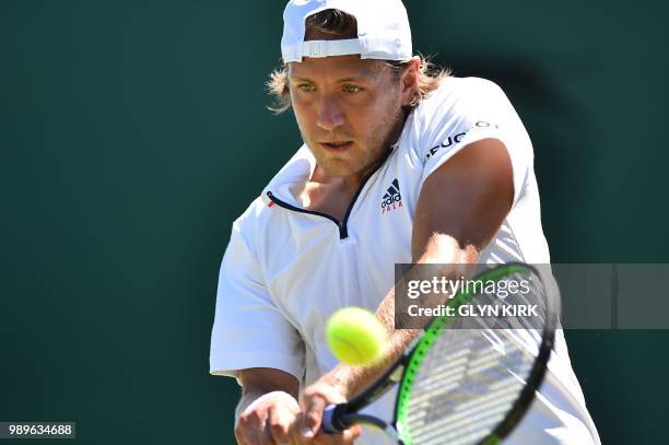 France's Lucas Pouille returns to US player Denis Kudla during their men's singles first round match on the first day of the 2018 Wimbledon...