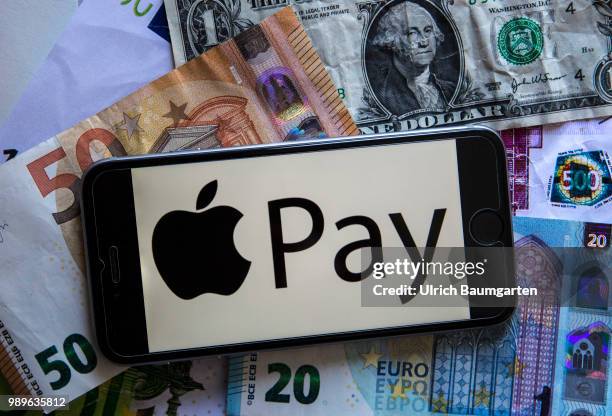 Symbol photo on the topic pay with the smartphone. The picture shows the Apple Pay logo on a smartphone display. The smartphone lies on euro and...