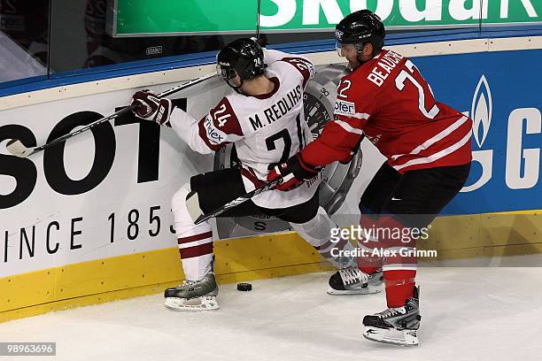 Mikelis Redlihs of Latvia is challenged by Francois Beauchemin of Canada during the IIHF World Championship group B match between Switzerland and...