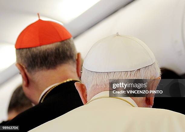 Pope Benedict XVI walks behind Cardinal Tarcisio Bertone at the end of his speech aboard a plane on the way to Portugal on May 11, 2010. Pope...