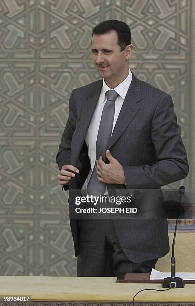 Syrian President Bashar al-Assad smiles as he leaves his seat at the end of his joint press conference with his Russian counterpart Dmitry Medvedev...