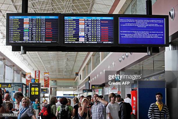 Passengers wait near information screens displaying cancelled flights at the Reina Sofial airport on the touristic Spanish Canary Island of Tenerife...