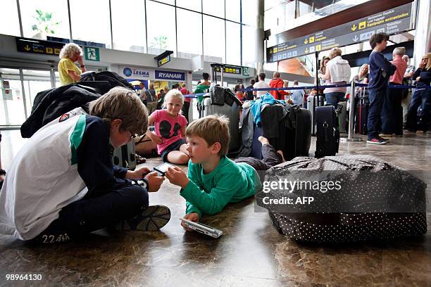 Passengers wait near information screens displaying cancelled flights at the Reina Sofial airport on the touristic Spanish Canary Island of Tenerife...