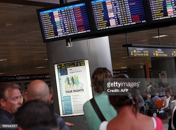 Passengers look at information screens displaying cancelled flights at the Reina Sofial airport on the touristic Spanish Canary Island of Tenerife on...