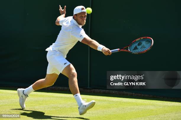 Player Denis Kudla returns to France's Lucas Pouille during their men's singles first round match on the first day of the 2018 Wimbledon...