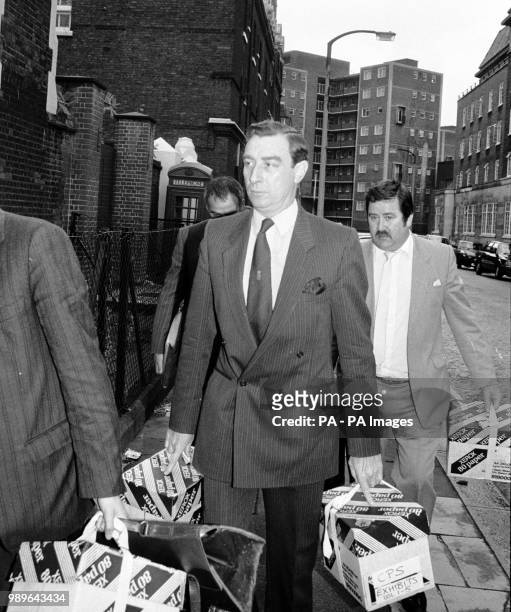 Chief Superintendent Brian Boyce, head of Scotland Yard's task force investigating the Brink's-Mat gold bullion robbery, carries boxes marked...