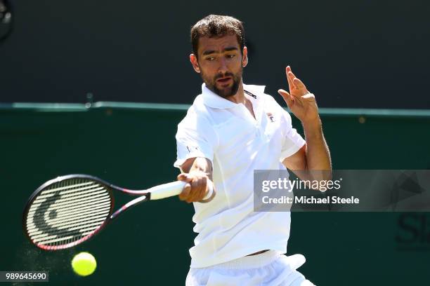 Marin Cilic of Croatia returns to Yoshihito Nishioka of Japan during their Men's Singles first round match on day one of the Wimbledon Lawn Tennis...
