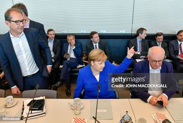 German Chancellor Angela Merkel sits next to Alexander Dobrindt , parliamentary group leader of the conservative Christian Social Union , and...