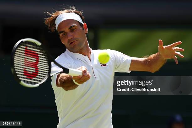 Roger Federer of Switzerland returns to Dusan Lajovic of Serbia during their Men's Singles first round match on day one of the Wimbledon Lawn Tennis...