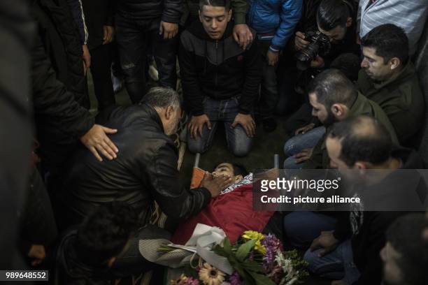 Palestinian mourner caress the face of 17-year-old Musab Tamimi, who was shot dead a day earlier in clashes with Israeli soldiers, during his funeral...