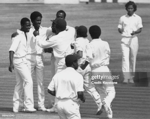 West Indian bowler Michael Holding is congratulated by his teammates after he bowled Dennis Amiss for 203 during the Fifth Test against England at...