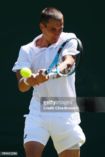 Evgeny Donskoy of Russia returns to Philipp Kohlschreiber of Germany during their Men's Singles first round match on day one of the Wimbledon Lawn...