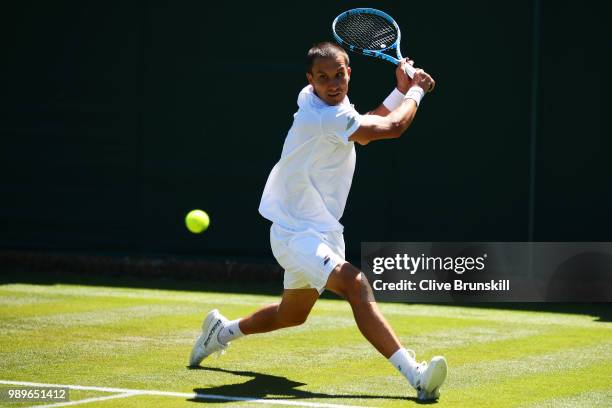 Evgeny Donskoy of Russia returns to Philipp Kohlschreiber of Germany during their Men's Singles first round match on day one of the Wimbledon Lawn...