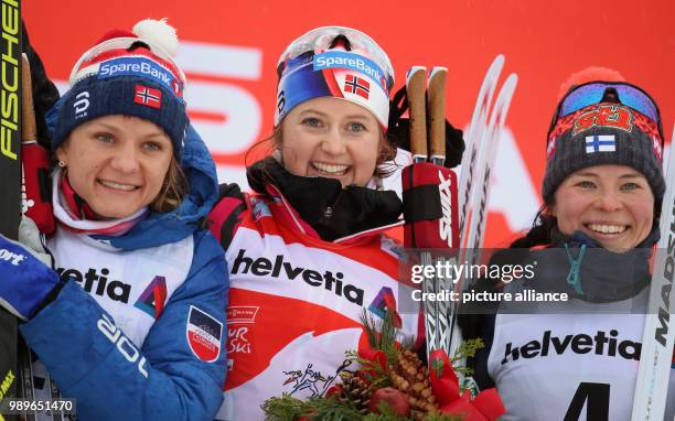 Maiken Caspersen Falla and Ingvild Flugstad Oestberg of Norway and Krista Parmakoski of Finland celebrate after the women's 10 km freestyle race at...