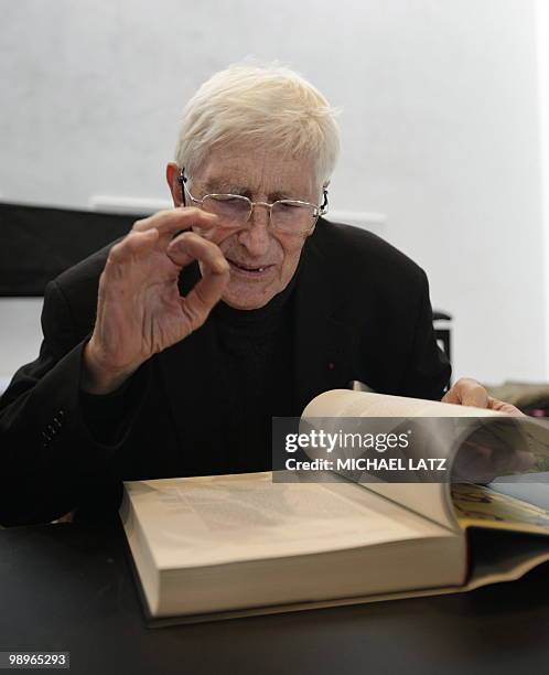 French illustrator and children's books author Tomi Ungerer browses the catalogue of his exhibition on May 11, 2010 during a preview of his...