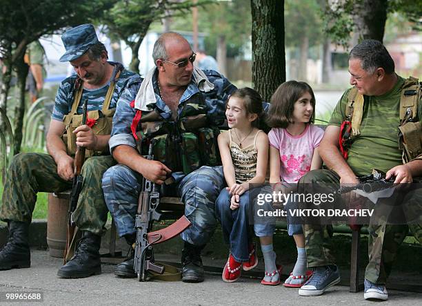 Local Abkhazian troops speak with young girls in the Georgian breakaway region of Abkhazia on the outskirts of the town Gali on August 12, 2008....