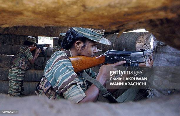 Female Liberation Tigers of Tamil Eelam guerrillas aim their weapons as they stand in a bunker located near the rebel front, 03 July 2006 north of...