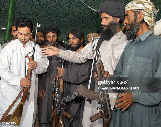 Pakistani tribesmen hand over their weapons to Baluchistan Provincial Home Minister Shoaib Nosherwani during a surrender ceremony in Quetta, 29 June...