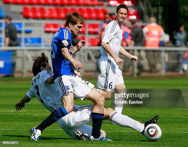 Vladimir Kuzmichyov of FC Saturn Moscow Oblast battles for the ball with Valeri Klimov of FC Tom Tomsk during the Russian Football League...