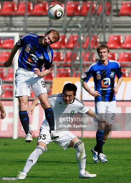 Aleksei Ivanov of FC Saturn Moscow Oblast battles for the ball with Kim Nam-Il of FC Tom Tomsk during the Russian Football League Championship match...