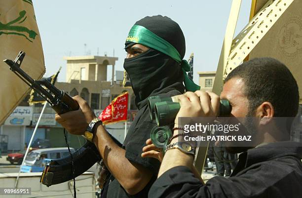 Members of radical leader Moqtada al-Sadr's Army of Mehdi watch a US army position in Baghdad's Shiite neighborhood of Sadr City 07 April 2004. AFP...
