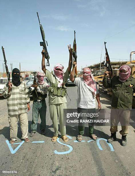 Armed Iraqi men welcome residents of Fallujah returning home 01 May 2004. A year after President George W. Bush declared an end to major combat...