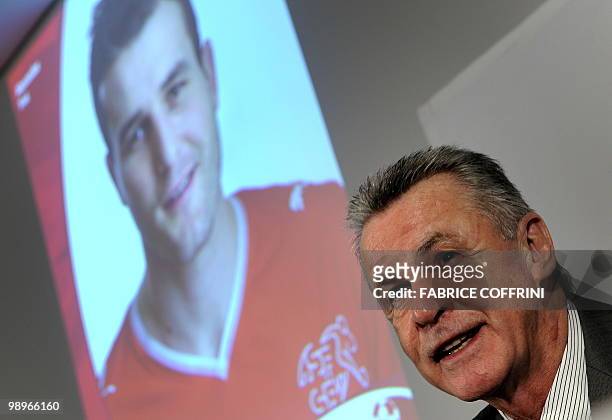 Coach of the Swiss football team German Ottmar Hitzfeld sits under a portrait of Swiss team captain Alexander Frei as he names the players for the...