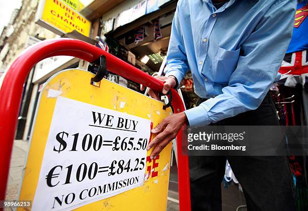 An employee writes the exchange rates for the euro on a board at a bureau de change in London, U.K., on Tuesday, May 11, 2010. The euro lost all of...