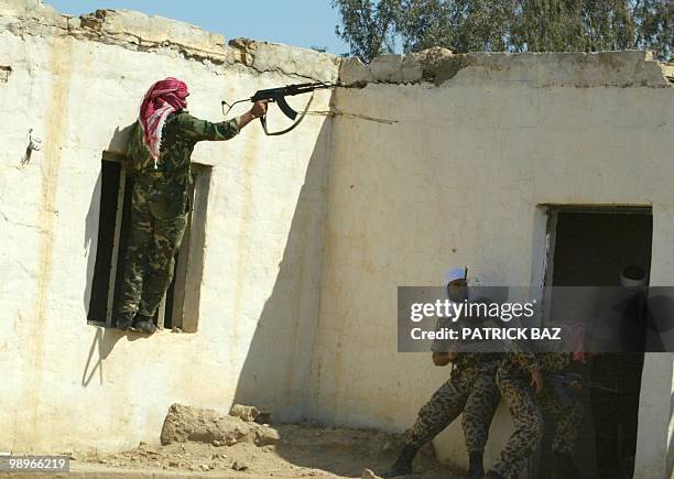 An Arab volunteer fires his Kalashnikov during a house to house search and urban combat drills with Iraqi special forces in a military camp at an...