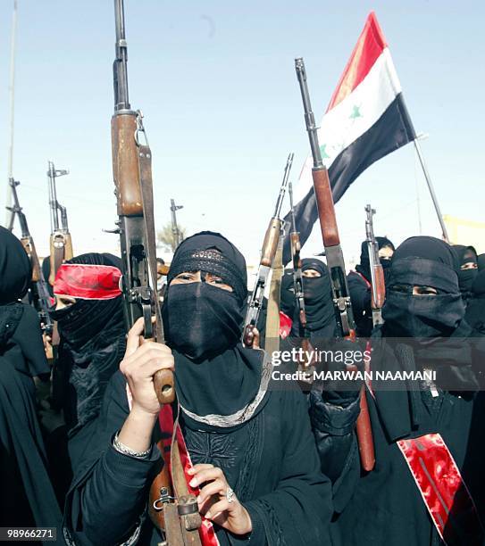 Iraqi women members of Iraq's Jaish al-Quds march in Tikrit, the president's home town 08 February 2003, on the 40th anniversary of a coup that...