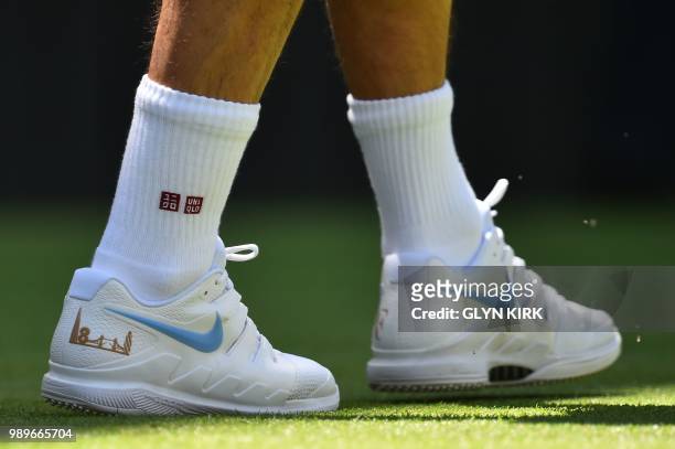 Switzerland's Roger Federer wears a pair of customised tennis shoes with an outline of the London skyline and the number of Wimbledon titles as he...