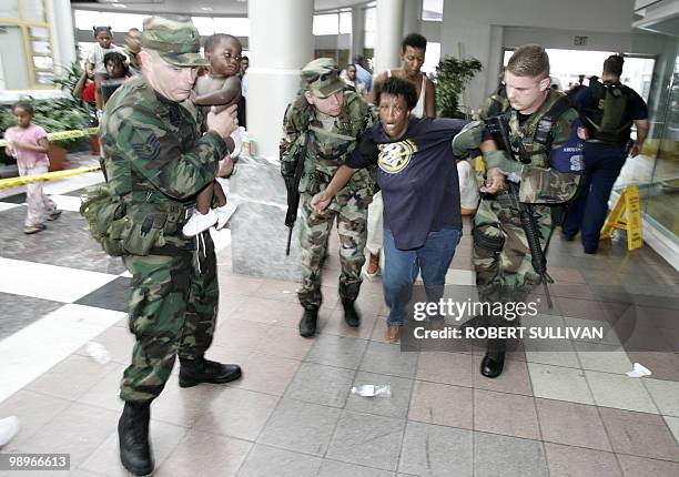 Woman in shock is helped by Louisiana National Guardsmen after gunshots were heard as people were evacuated from the Superdome in New Orleans 01...