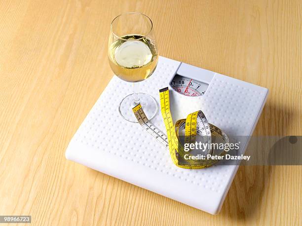 white wine and tape measure on bathroom scales - peter dazeley stock pictures, royalty-free photos & images