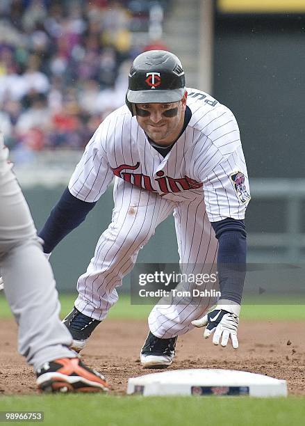 Nick Punto of the Minnesota Twins dives for first base on a pick off attempt during a game against the Baltimore Orioles at Target Field on May 8,...